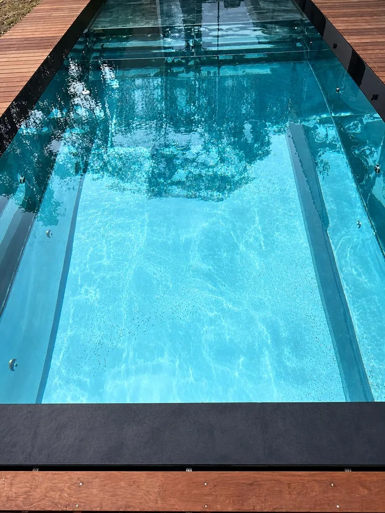 Couloir de nage bordé d'une terrasse en bois.